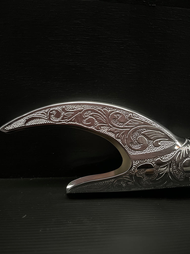 An ornate Reaper Exhaust Tips on a black surface by Cuztom Kraft.