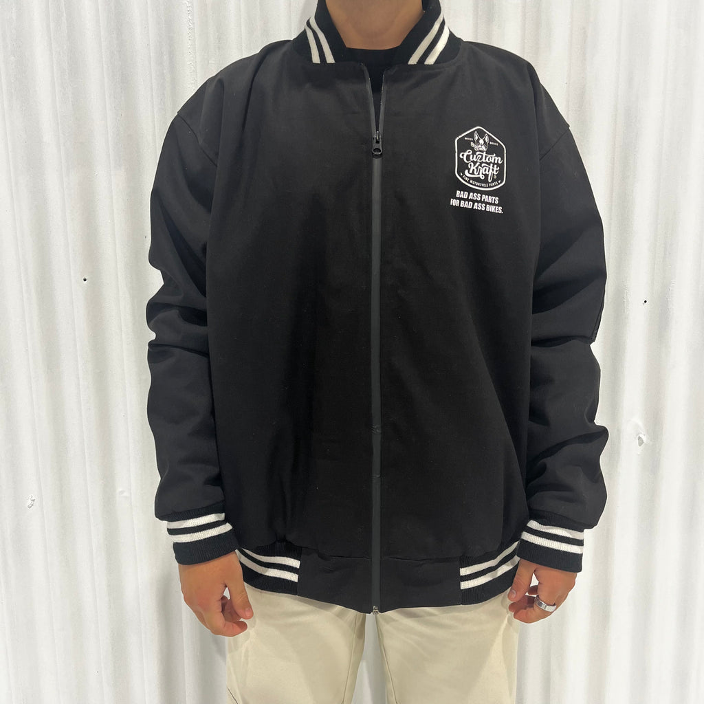 A man wearing a black Cuztom Kraft 'Bad Ass' jacket in different sizes.