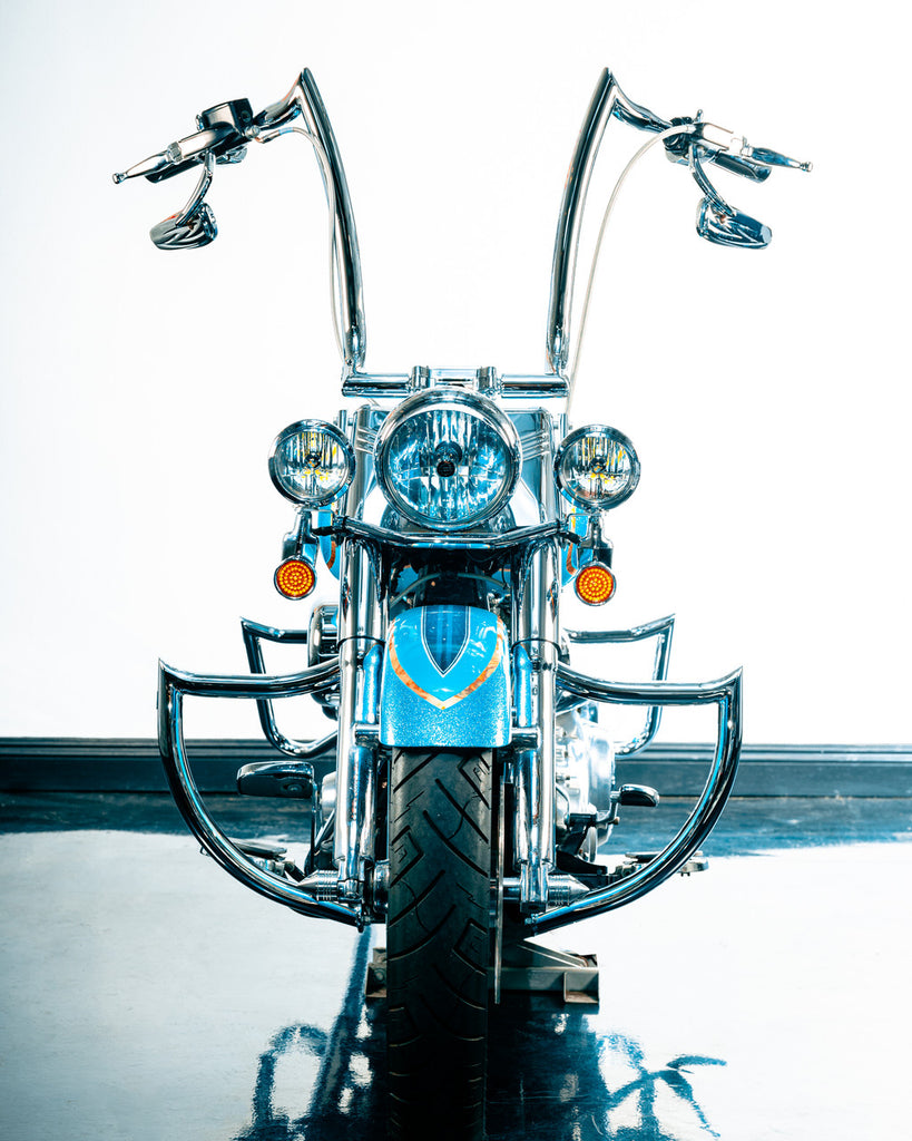 A blue Factory 47 motorcycle parked in a room.