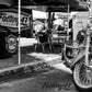A black and white photo of a Factory 47 Shield 2001-2017 Softail motorcycle parked under a tent.