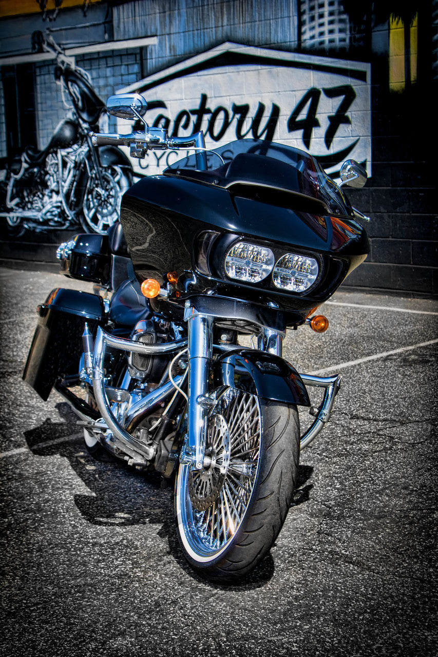 A black Factory 47 Signature Handlebar Chrome 14" motorcycle parked in front of a building.