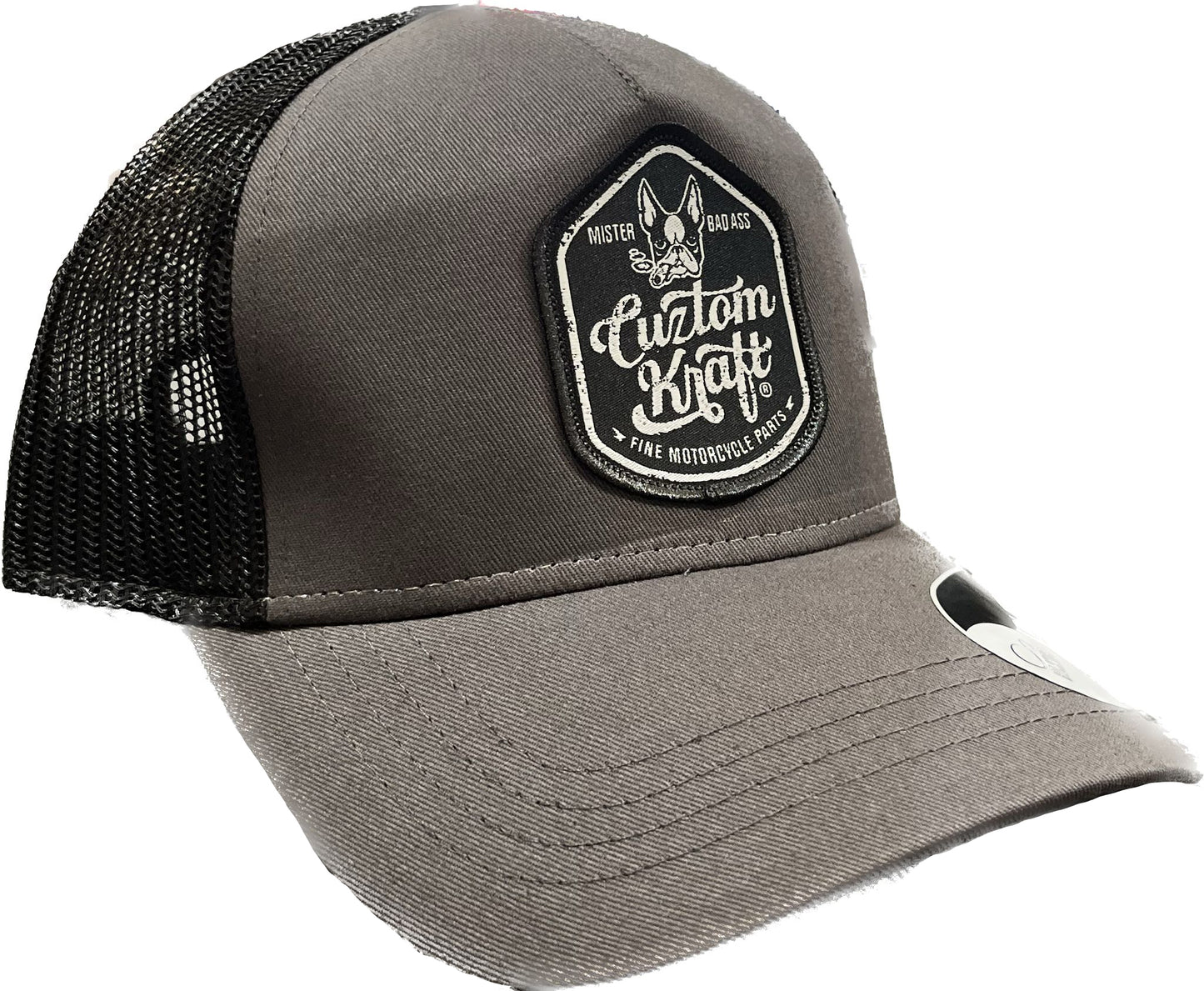 A gray trucker hat with a black Bad Ass Patch on it made by Cuztom Kraft.
