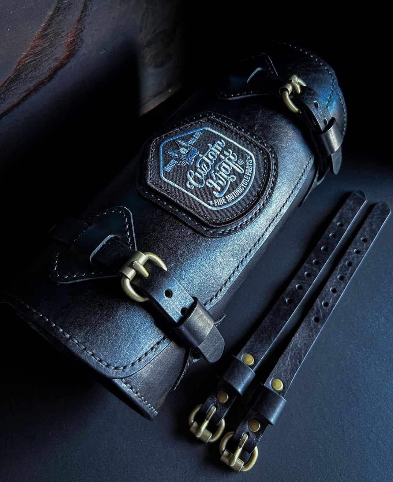 A Cuztom Kraft black leather belt with brass buckles on it.